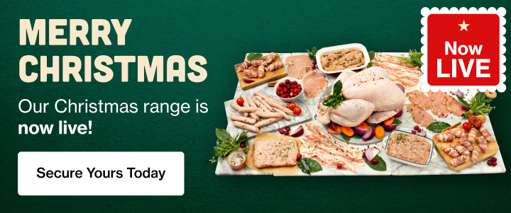 A large variety of festive raw meats arranged on marble boards with whole turkey at the centre