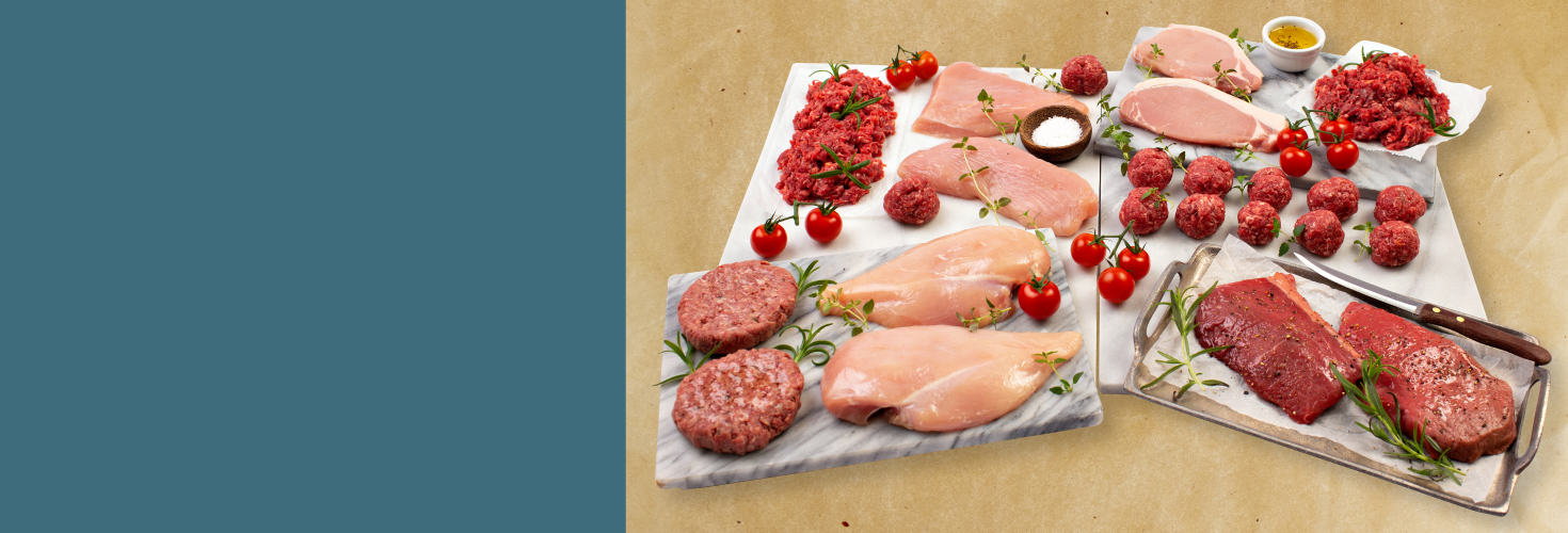 A variety of raw meats arranged on chopping boards