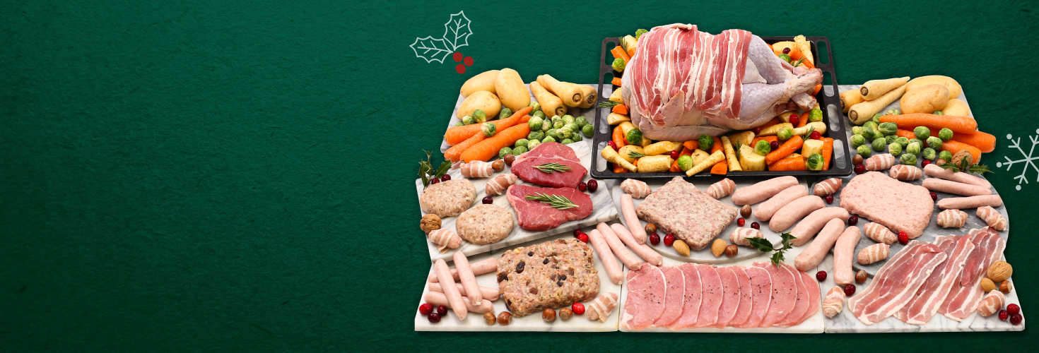 A variety of raw meats with a bacon covered turkey as the centrepiece