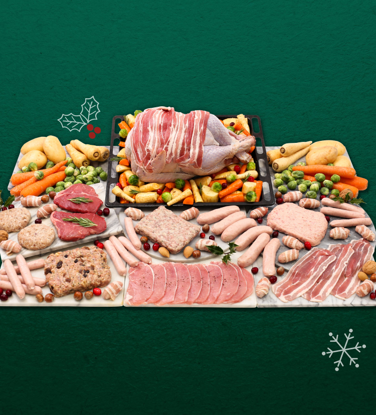 A variety of raw meats with a bacon covered turkey as the centrepiece