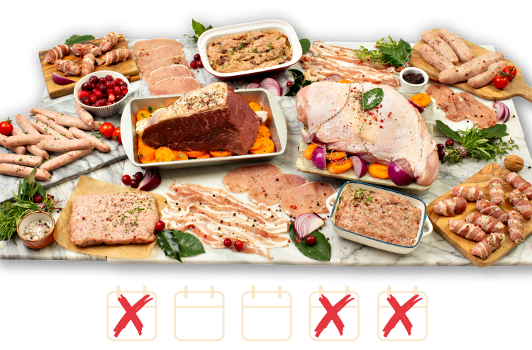 A large variety of festive raw meats arranged on marble boards with turkey butterfly and beef joint at the centre