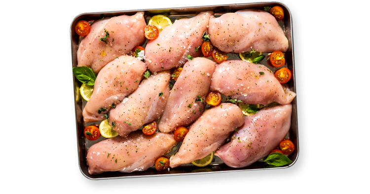 10 large chicken breast fillets on a baking tray with tomato, lemon and basil garnish